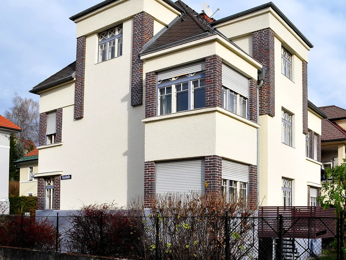 Österreichisches Wohnhaus mit Gartenzaun und klar erkennbarem Grundstücksbereich